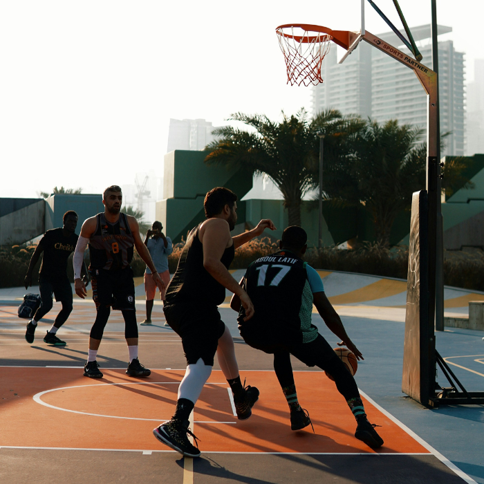 men playing competitive   outdoor basketball