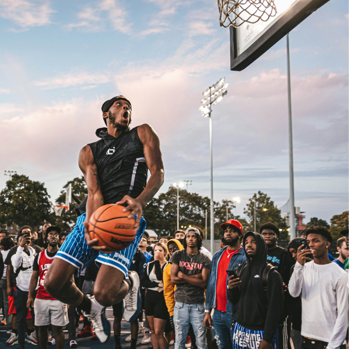 man dunking ball with large crowd watching